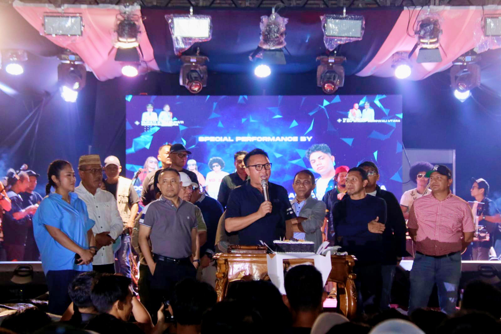 Bupati Morowali Utara (Morut) Delis J Hehi menyapa warga dari atas panggung pada puncak perayaan HUT ke-12 Morut, Kamis (23/10/2025). Foto: DInskominfo Morut