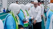 Wakil Bupati Morowali Utara Djira berjabat tangan dengan dengan jamaah pada momen pelepasan Jamaah Calon Haji (JCH) di Kolonodale, Rabu (13/5/2026). Foto: MDCC